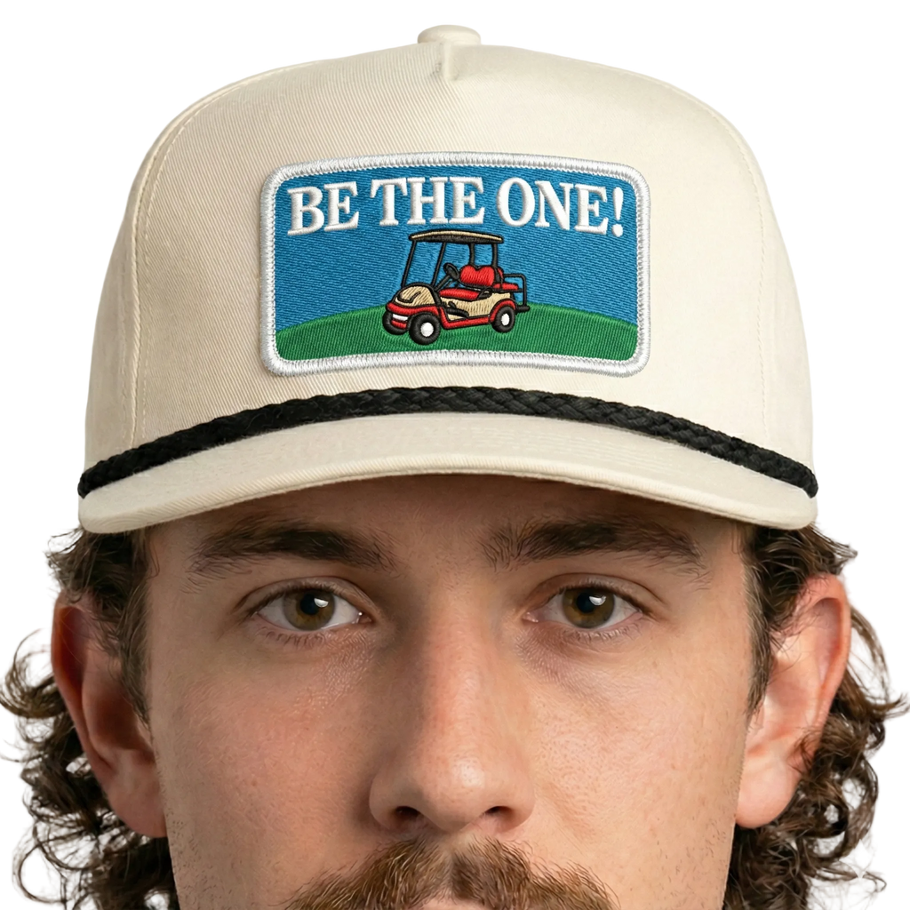 Man wearing a cap with 'Be the One!' and golf cart graphic