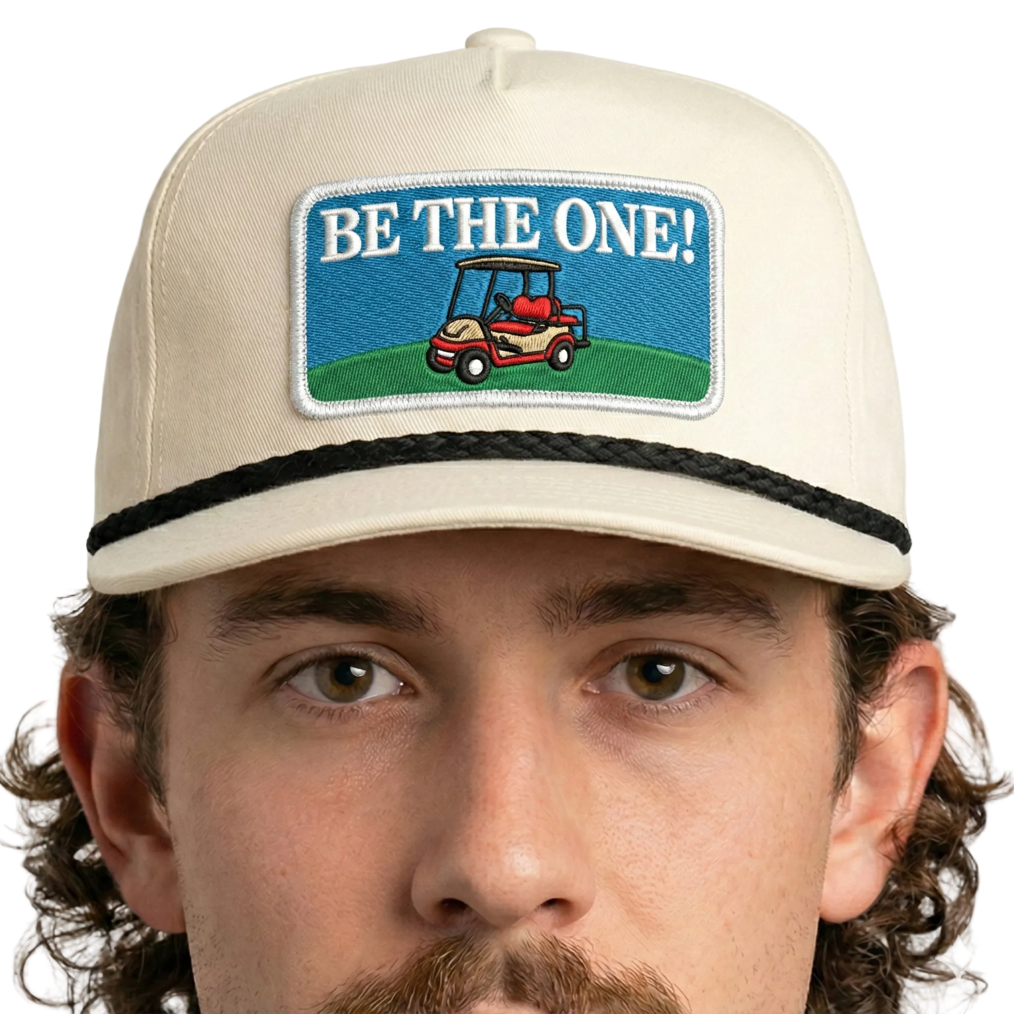 Man wearing a cap with 'Be the One!' and golf cart graphic